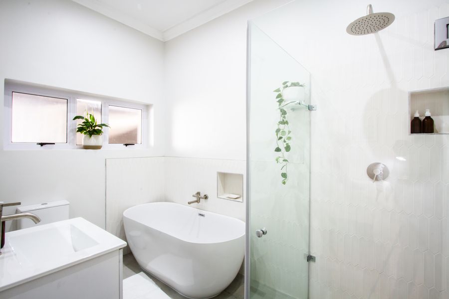 The main bedroom's en-suite, with a freestanding bath and rain shower