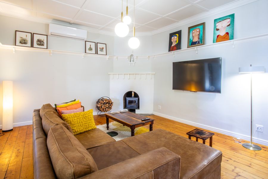 Lounge with leather sofas, fireplace and wall-mounted TV